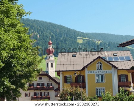 The center of Niederdorf-Villabassa with the well known red church and the Villa Fauster. The picture was taken from the Train Station in the directiom of the town center.