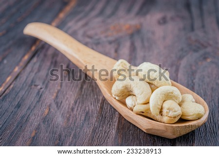 Cashew on spoon on wooden background - vintage effect style pictures