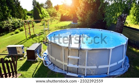 Swimming pool with metal frame for home and garden. Frame swimming pool in the yard. Garden in the background. Summer holiday fun and recreation. Royalty-Free Stock Photo #2332392559