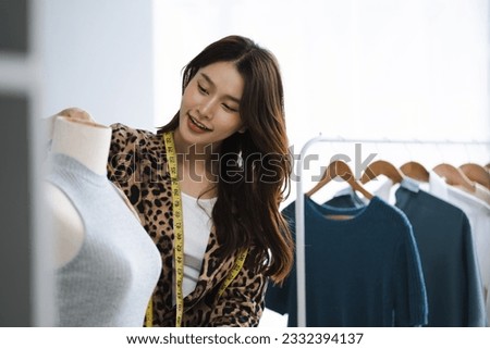 Shot of a young woman fashion designer working on a garment hanging over a mannequin.