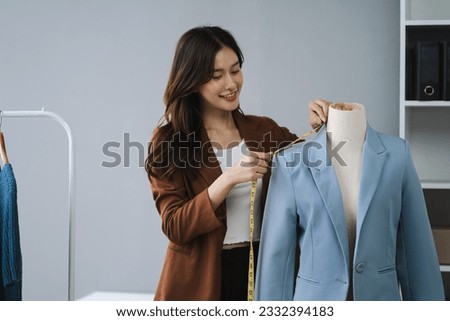 Shot of a young woman fashion designer working on a garment hanging over a mannequin.