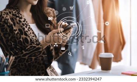 Female fashion designers use smart phones and use laptops with digital tablet computers to get orders from customers.