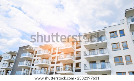 Contemporary residential building exterior in the daylight. Modern apartment buildings on a sunny day with a blue sky. Facade of a modern apartment building.  Royalty-Free Stock Photo #2332397631