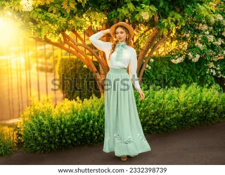 Art Fantasy young woman in vintage straw hat on head walking in garden, girl princess pretty face red hair, retro old style white blouse mint skirt, bow tie. green grass yellow sun light summer nature Royalty-Free Stock Photo #2332398739