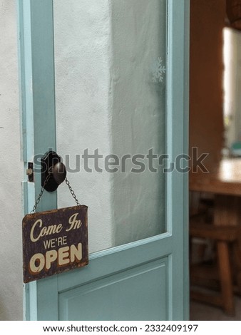 Vintage door, wooden sign and welcome message come in we are open