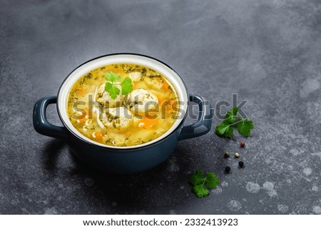 Summer low calorie meatball soup in pot on dark background. Top view, copy space, flat lay. Royalty-Free Stock Photo #2332413923