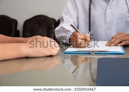 The smart doctor took a history of illness. The medicine doctor writing a medical prescription order some treatment for patient in the hospital.