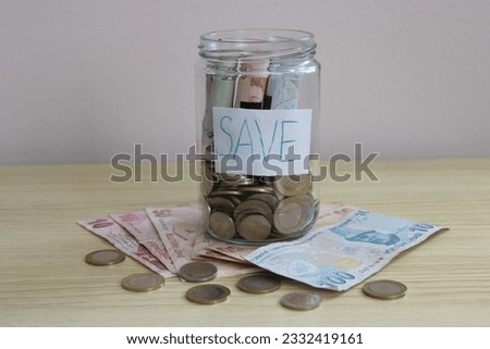 the inscription save with the iron and paper money in the jar. financial growth or money saving concept. 