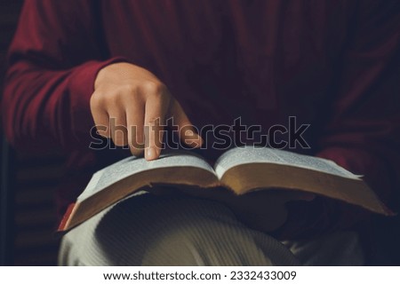 Christian man's hands while reading the Bible outside.Sunday readings, Bible education. spirituality and religion concept. Reading a book.education learning  Royalty-Free Stock Photo #2332433009
