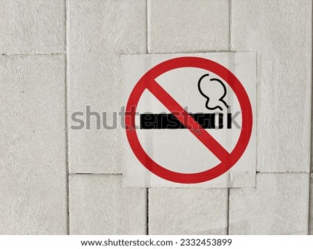 “No smoking” sign on the white brick wall