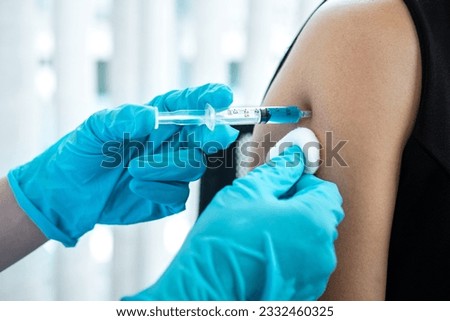 Doctor making a vaccination into patient with needle getting immune vaccine at arm for flu shot, coronavirus protective of epidemic. Royalty-Free Stock Photo #2332460325