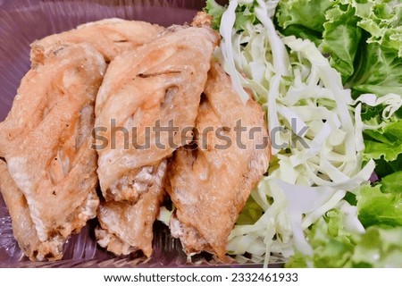 a photography of a plate of food with lettuce and chicken, there is a plate of food with lettuce and chicken on it.
