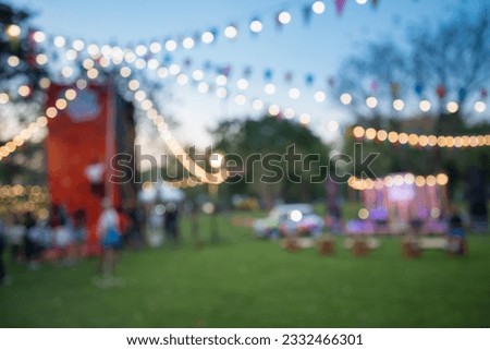 Abstract blur people in night outdoor festival city park bokeh background. Outdoor festive, party, celebration season concept.