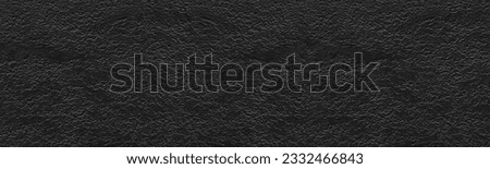 Black textured plaster wide wall. Dark rough cement texture.  Gloomy grunge panoramic background