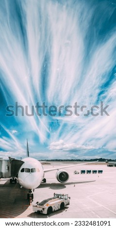Aircraft Plane Boarding Passengers In Airport Terminal. Aircraft Tow Tractor And Fright Forklift Near Plane. Royalty-Free Stock Photo #2332481091