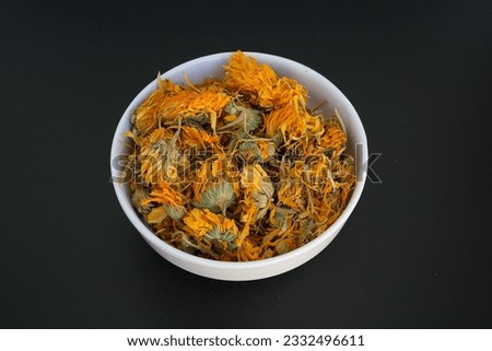 Calendula Flower in a white plate on a black background