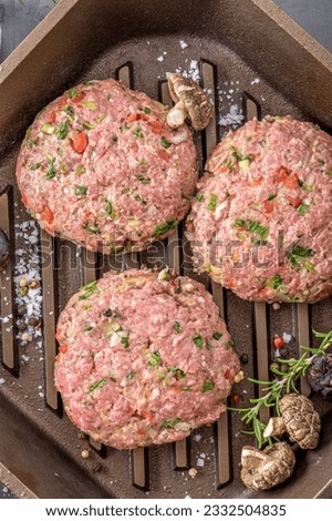 Gourmet Creation: Top View of Raw Hamburger Patties with Spices Sizzling in a Cast Iron Pan, Awaiting Culinary Perfection in 4K Resolution