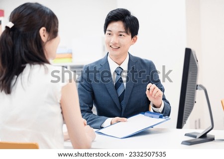 A male staff member listening to a customer's request at the counter Royalty-Free Stock Photo #2332507535