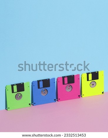 Colored Floppy disks on a pink blue background. Retro 80s. Outdated technology. Creative layout, minimalism, trendy minimal still life