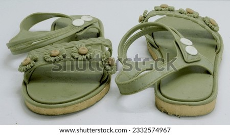 Photo of a pair of green sandals on a white floor, gaiters while traveling