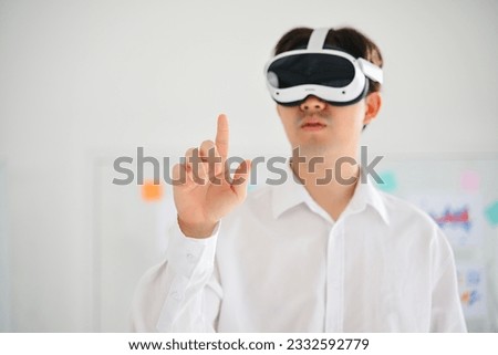 Businessman wearing virtual reality goggles headset and touching AI world, Happy man touching digital pixel screen in modern office, Futuristic lifestyle. High quality photo