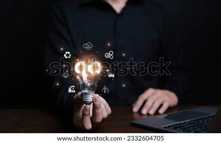 Businessman holding light bulb with infinity symbol with business economy environment icons around light bulb. Future sustainable investment growth, Reduce environmental pollution, sustainable energy,
