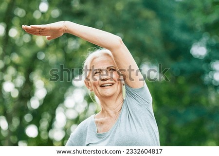 Portrait of a happy beautiful elderly senior mature woman exercising and stretching outdoors Royalty-Free Stock Photo #2332604817