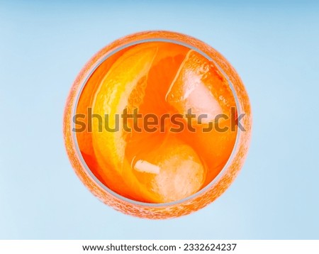 Aperol Spritz cocktail in glass on a blue background. Cocktail Aperol Spritz with orange slice and ice cubes. Top view Royalty-Free Stock Photo #2332624237