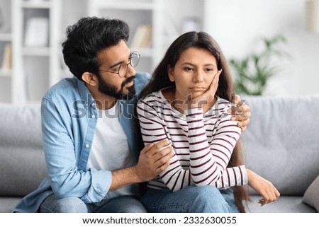 Compassionate eastern husband giving comfort, support to upset wife, holding shoulders, speaking expressing empathy. Man feeling guilty, asking girlfriend to forgive. Relationship, compassion concept