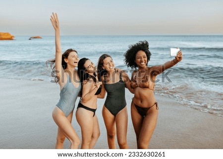 Capturing summer vacation time. Carefree diverse women taking picture together at the beach, female friends having fun and making memories