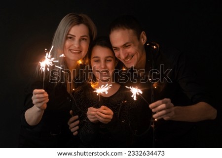 family with sparklers on a black background