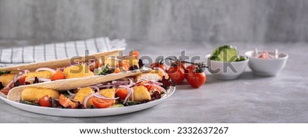 Delicious tortilla with chicken nuggets, vegetables, onions and lettuce on a plate web banner