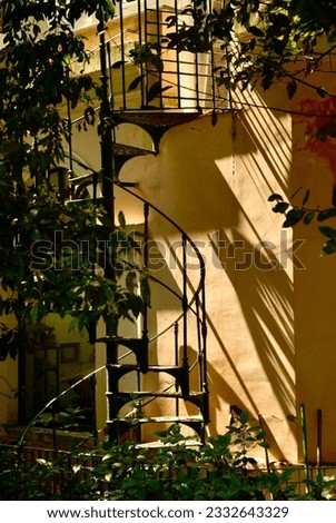 A circular stairway to a home found in the the Villa Borghese Gardens in Rome Italy reflects sunlight and creates shadow patterns that change as the sun moves across the sky.