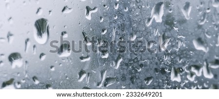 Banner Raindrops on the window. Water falling on the glass. natural background, freshness. Cold rainy weather. Close-up.