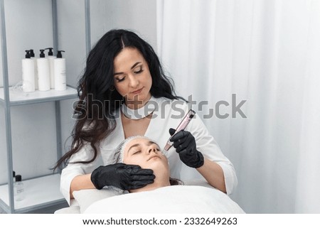 cosmetologist making mesotherapy injection with dermapen on face for rejuvenation. Anti-aging treatment and face lift in cosmetology clinic. medical procedure with Electric pen for derma stamp Royalty-Free Stock Photo #2332649263