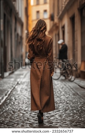 Lonely woman wearing long brown fancy coat. Autumn casual fashion street style. Back view Royalty-Free Stock Photo #2332656737