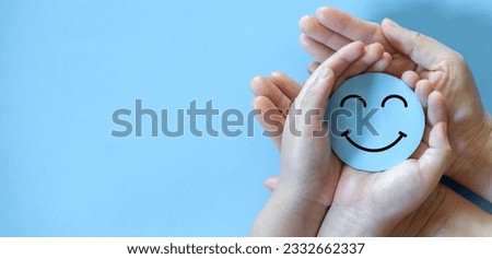 Hand holding paper cut circle symbol face smile, happy, relax, satisfaction survey, customer services, positive, good, wellness, health child, hospital, world mental health day concept Royalty-Free Stock Photo #2332662337