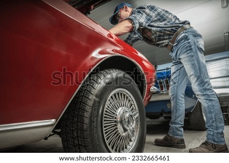 Classic Muscle Car Restoration Performed by Caucasian Professional Mechanic Royalty-Free Stock Photo #2332665461