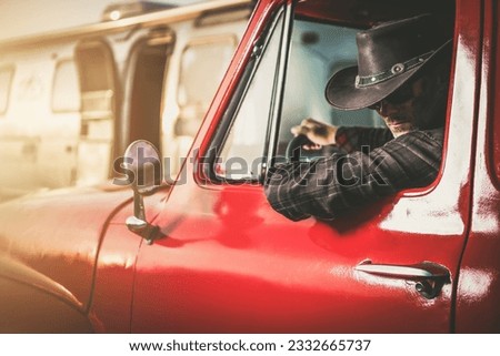 Middle Aged Caucasian Cowboy in a Classic Pickup Truck Next to His Travel Trailer