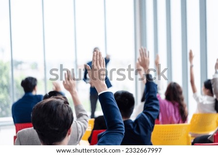 Business person raising hand during seminar. Hand up in conference asking to answer a question in business meeting room and seminar class. Royalty-Free Stock Photo #2332667997