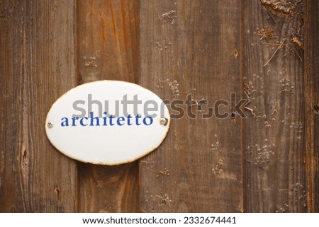 closeup of a white billboard with blue letters on which you can read the word architect in italian language
