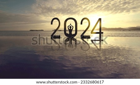 Silhouette of young woman exercising yoga while doing meditation with 2024 new year numbers on the beach at sunrise time Royalty-Free Stock Photo #2332680617