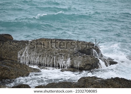 Sea waves hitting rocks,Sea waves hitting rocks in a beautiful beach with mountain background.Ocean waves,selective focus.