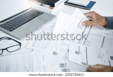 A man working at home with computer laptop to start new business online checking order and receipt and confirm orders from customers through online sales Royalty-Free Stock Photo #2332720411