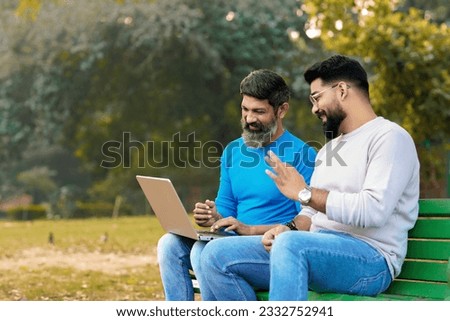 Two indian male discuss and using laptop at park Royalty-Free Stock Photo #2332752941