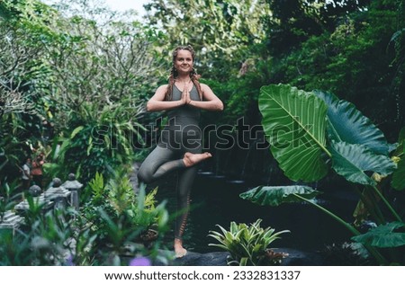 Good looking female in namaste pose enjoying recreation in asana for training balance, Caucasian woman in spandex sportswear doing yoga practice at feeling harmony and vitality Royalty-Free Stock Photo #2332831337