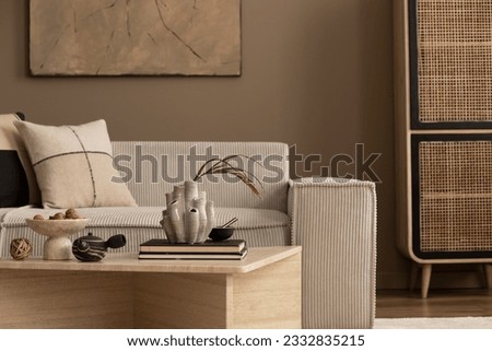 Interior design of cozy living room with mock up poster frame, modular sofa, gray armchair, travertine coffee table, braided basket, rattan sideboard and personal accessories. Home decor. Template.
