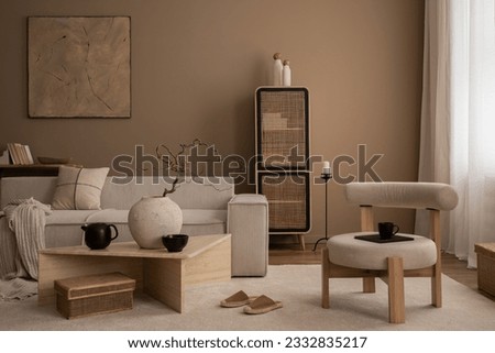 Elegant composition of warm living room interior with mock up poster frame, modular sofa, travertine coffee table, gray armchair, rattan sideboard, lamp and personal accessories. Home decor. Template. Royalty-Free Stock Photo #2332835217
