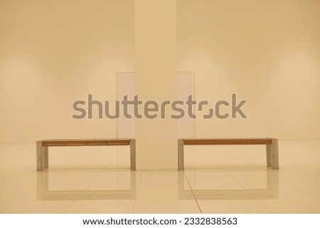 A symmetrical of brown wooden chairs in a white hallway. Hall interior with large building column. Bright empty hall. Workplace and lifestyle, Modern white hall concept. Symmetrical interior conpect.