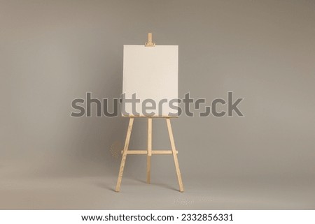Wooden easel with blank canvas on grey background Royalty-Free Stock Photo #2332856331